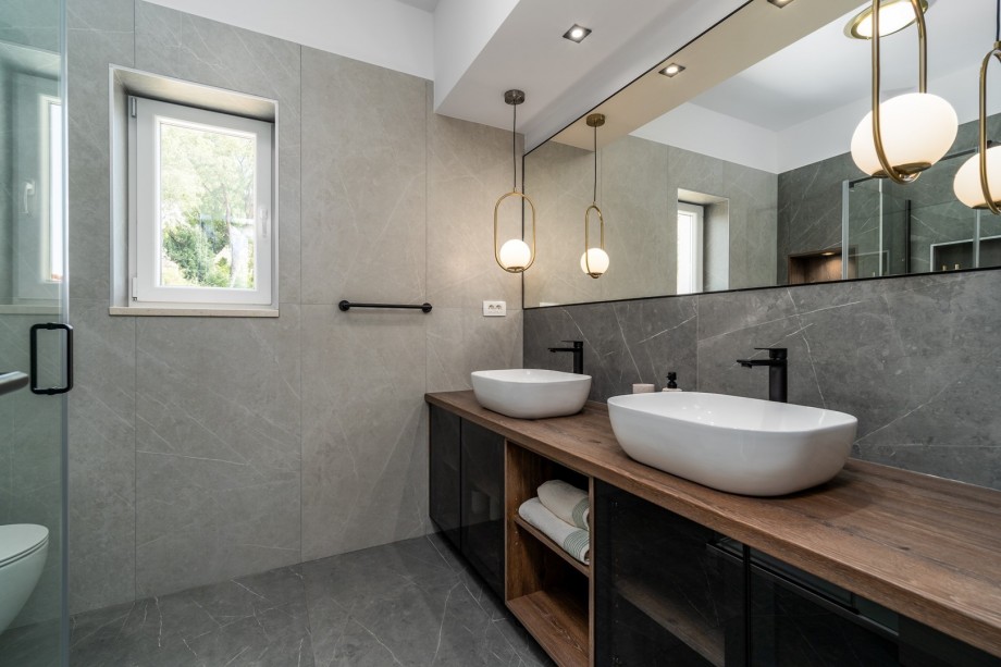 A Family bathroom with a shower, a double sink, and a toilet
