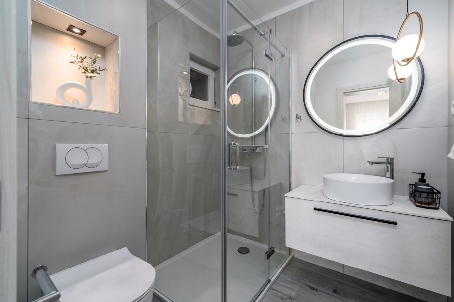 An en-suite bathroom with a shower, a sink, and a toilet
