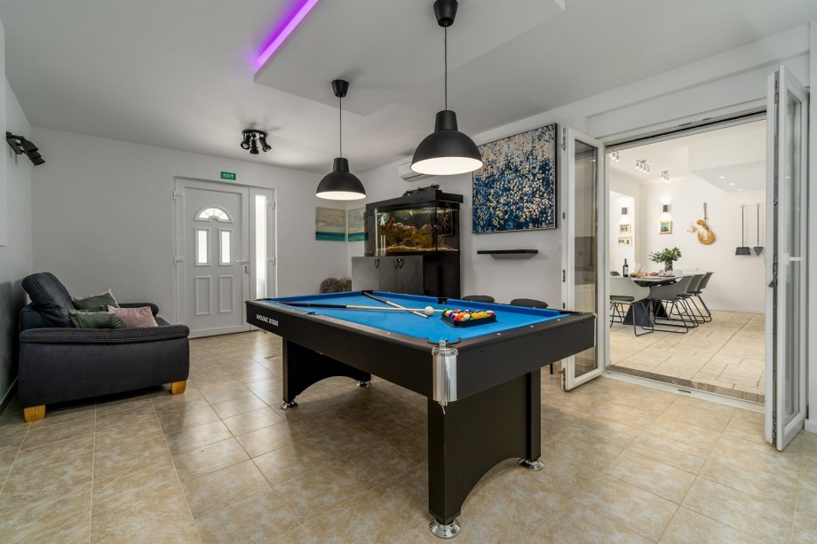 An aquarium with Adriatic sea fishes and a sofa.