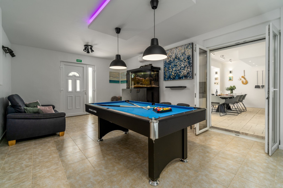 An aquarium with Adriatic sea fishes and a sofa.