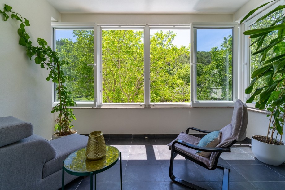 A balcony with relaxing views on the pool and natural surroundings.