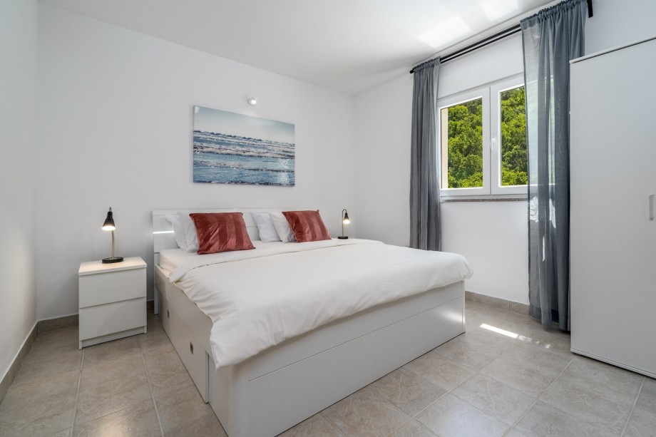 A Bedroom No1 with a king size bed 180cm x 200cm, air-condition, a TV and the views on the pool area.