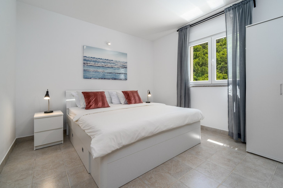 A Bedroom No1 with a king size bed 180cm x 200cm, air-condition, a TV and the views on the pool area.