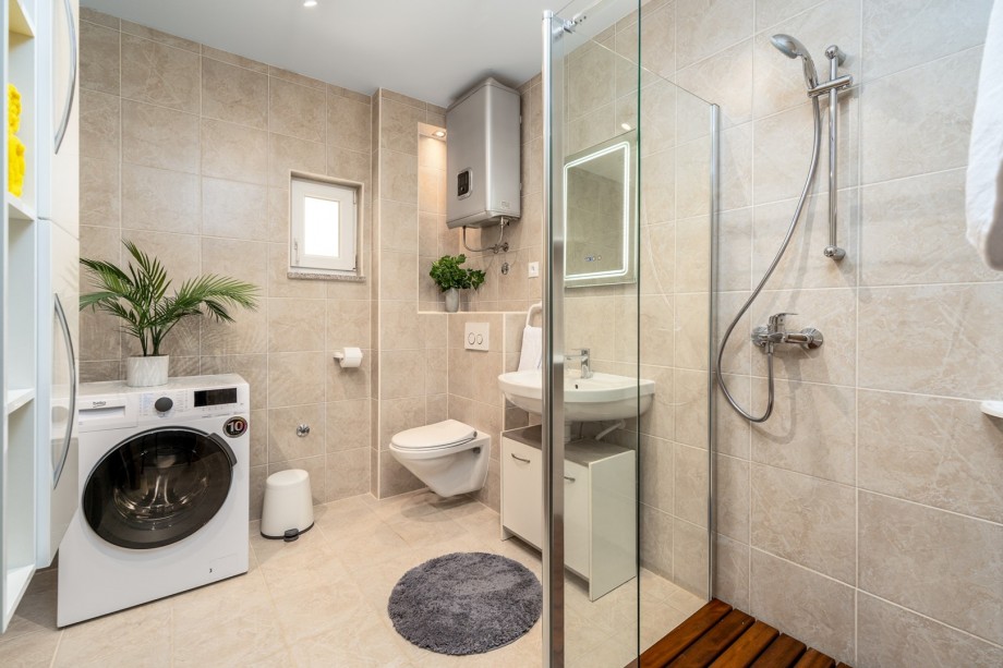 There is a family bathroom with a shower, a washing machine, a dryer and ironing facilities