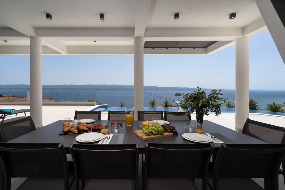 Covered outdoor dining area with modern grill