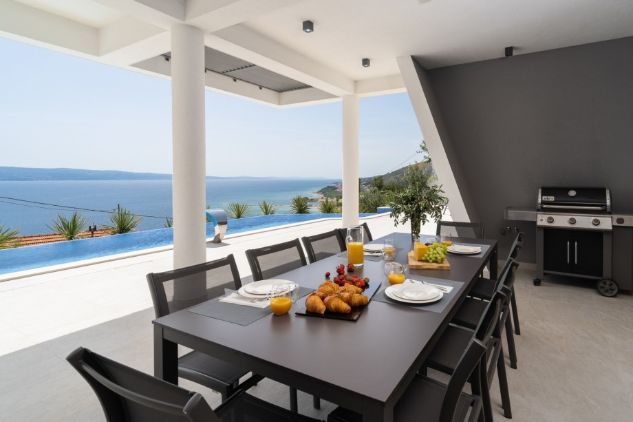 Covered outdoor dining area with modern grill