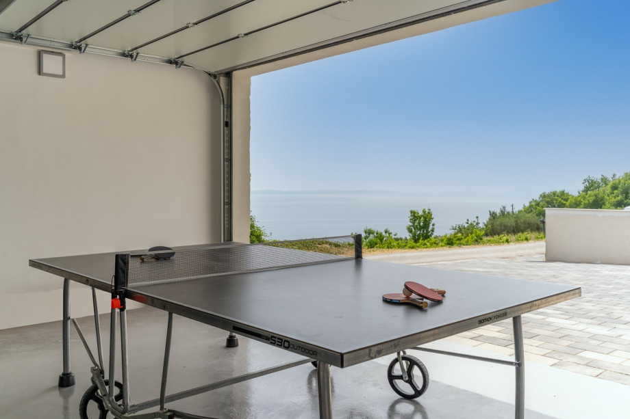 There is outdoor table tennis in the garage, a portable basketball hoop and a secured parking lot for 2 cars.