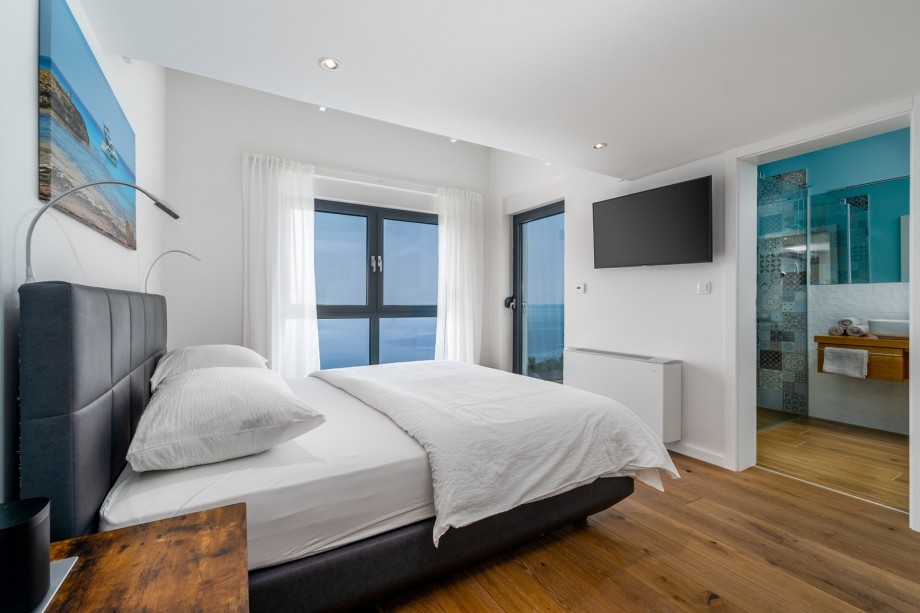 En-suite bathroom with a shower and a toilet, a balcony with amazing sea views.