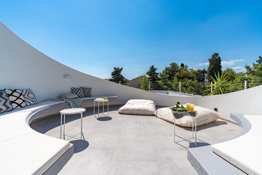 Roof-top outdoor offers a fenced round shape lounge area spread on 23,2 sqm for relaxation with views of the neighborhood