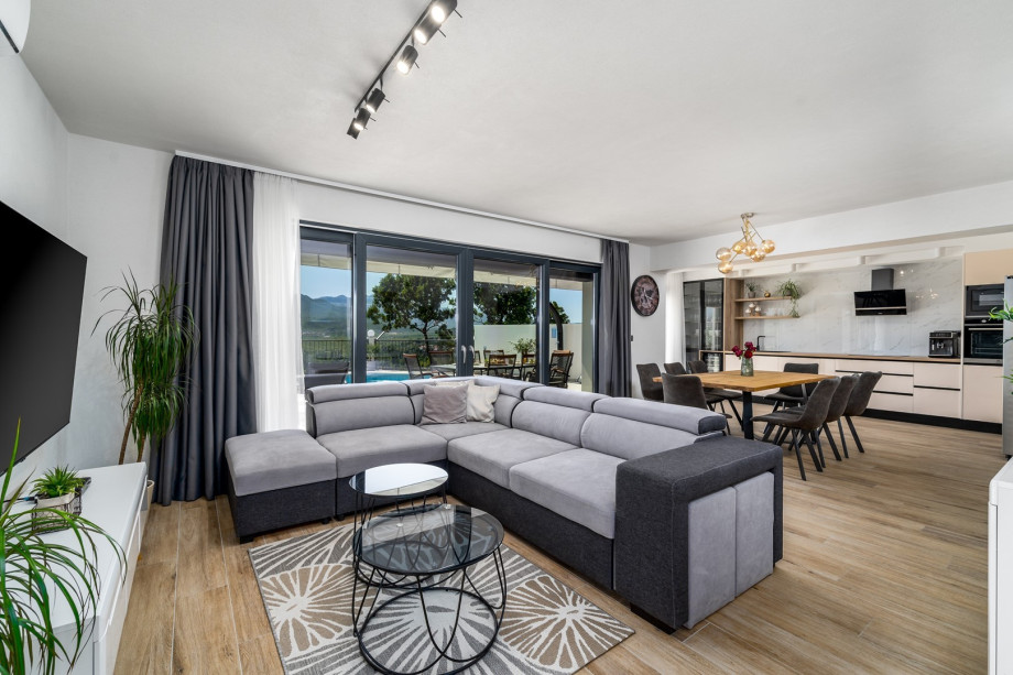 A living room with a sofa (which can open into a sofa bed) , a flat-screen TV, free WiFi and a direct approach to the pool and outdoor area