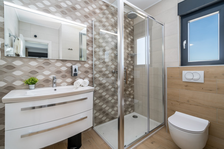 An en-suite bathroom with a shower, a sink, and a toilet