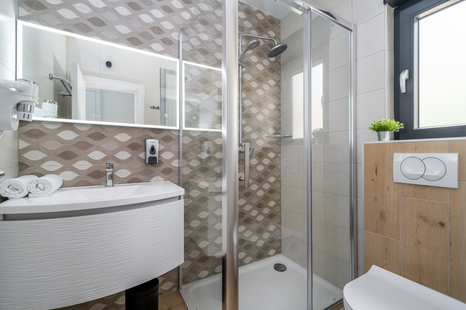 An en-suite bathroom with a shower, a sink, and a toilet