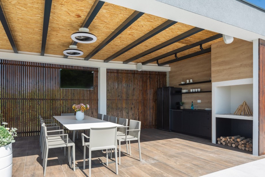 The outdoors offers a covered dining area  and a traditional barbecue