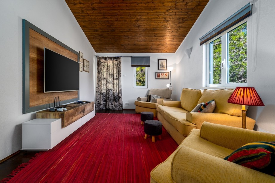 A second living room (first floor) with cozy sofas, flat-screen TV, Xbox, and a couple of games