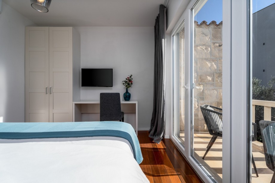 Bedroom No1 with a balcony with two chairs, sea and pool views.