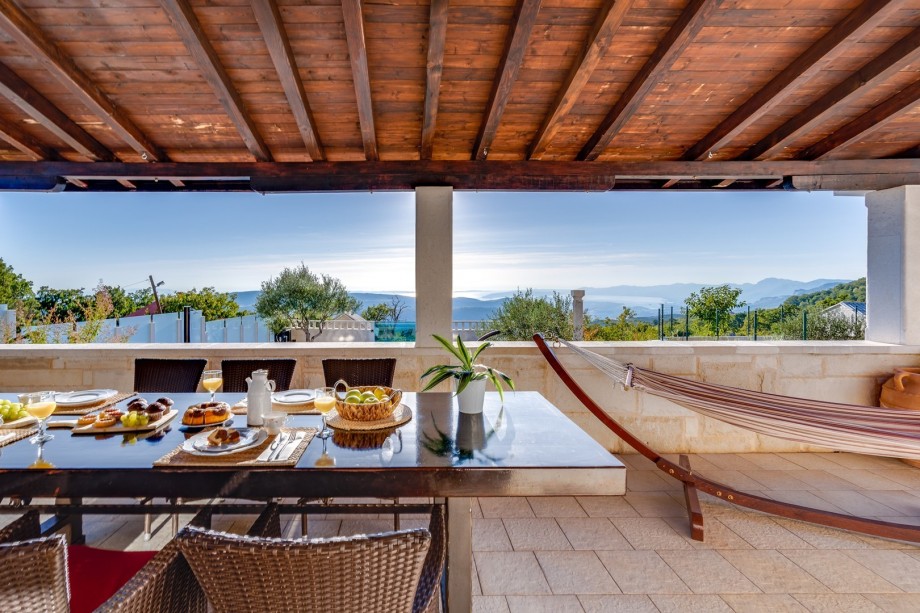 Spacious, covered terrace with outdoor dining area between pool and living area