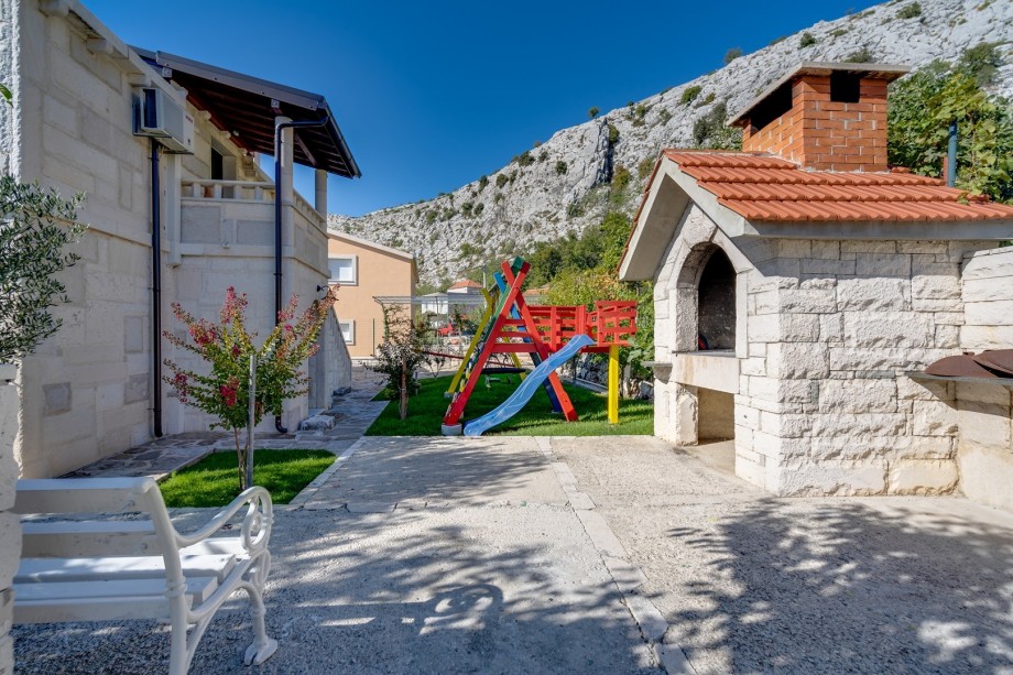 The traditional barbecue behind the house next to the playground