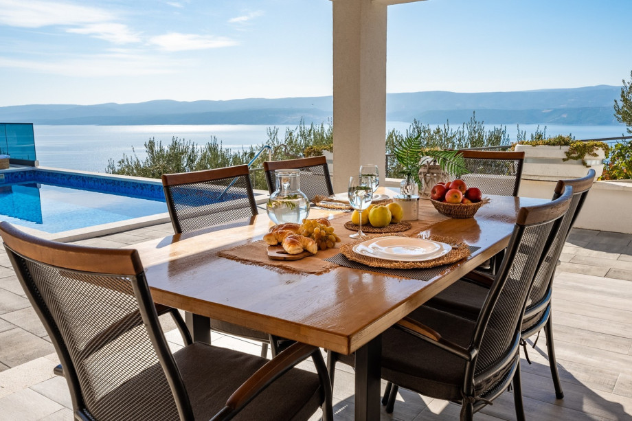 Covered outdoor dining area for 6 people with TV and a barbecue