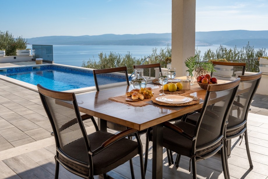 Covered outdoor dining area for 6 people with TV and a barbecue