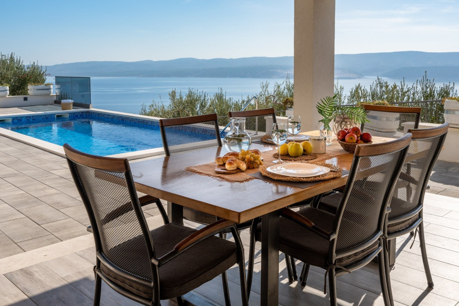 Covered outdoor dining area for 6 people with TV and a barbecue