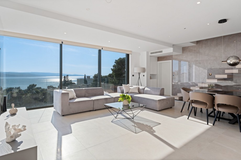 Luxuriously furnished living and dining area with glass wall on the sea side, first floor