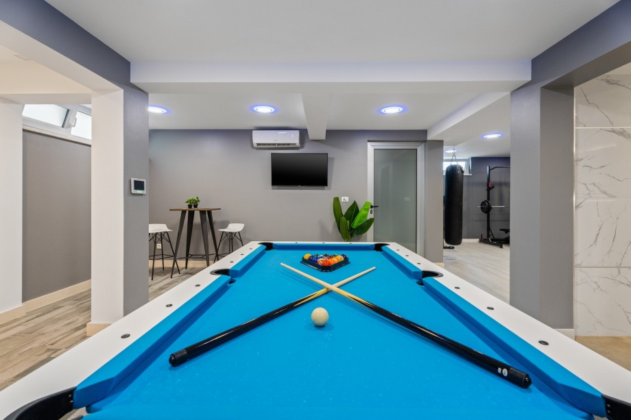 There is a billiard, a bar, a sofa with TV, Netflix, and a PS4 for young members