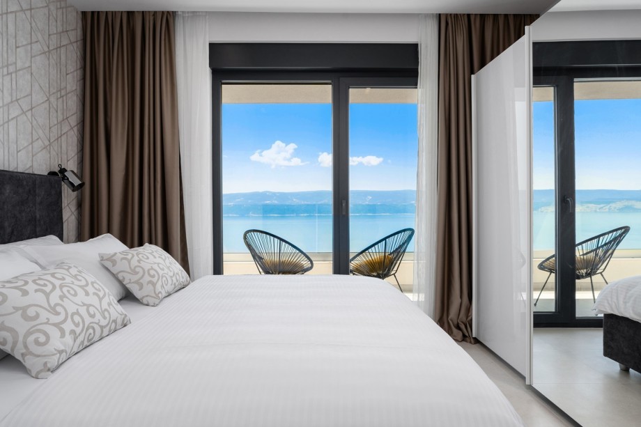 Bedroom NO1 (23,5sqm) with a king-size bed 180cmx210cm, and balcony with sea views and outdoor furniture.