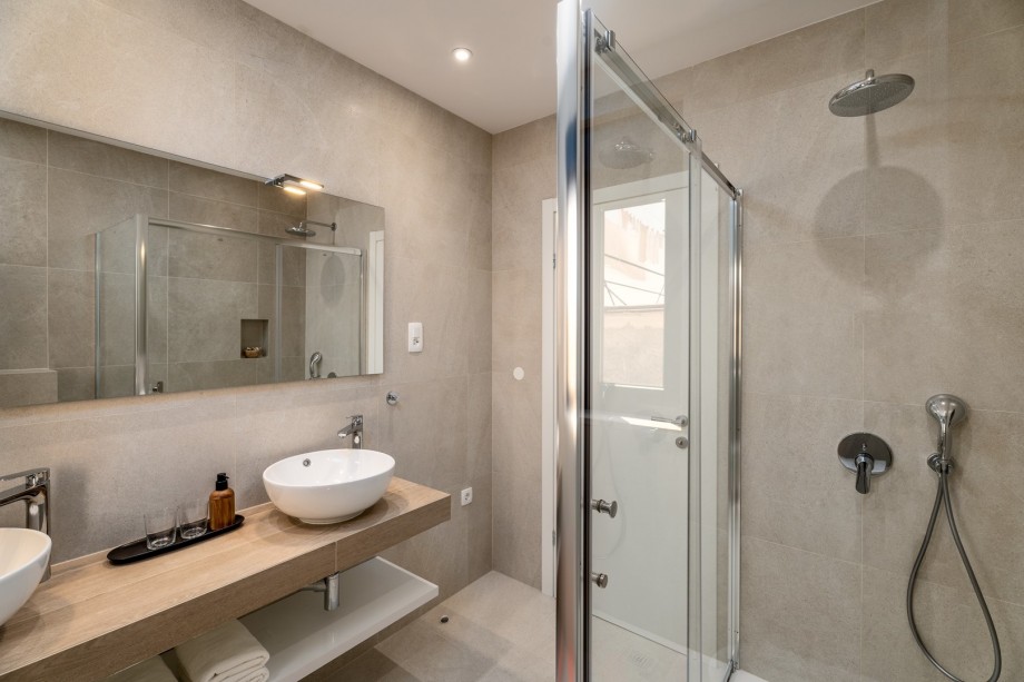 En-suite bathroom with a shower, double sink, and toilet.