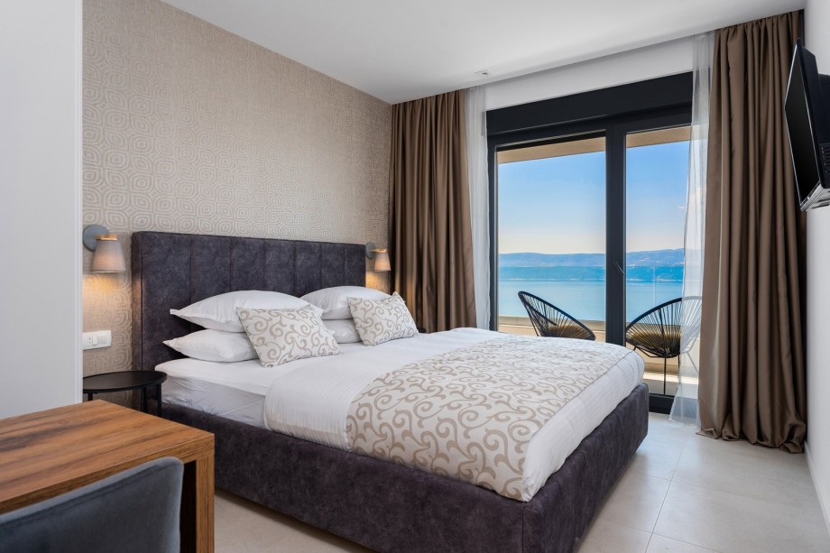 Bedroom NO2 with a terrace with sea views and outdoor furniture.