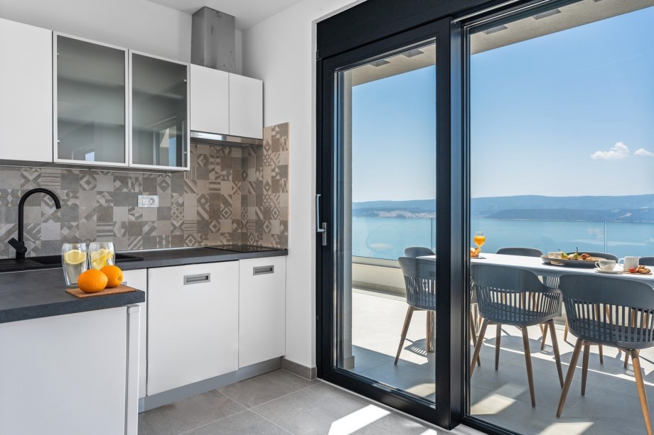 A kitchenette with a mini fridge and utilities provide, a sea view and a terrace with a sitting area