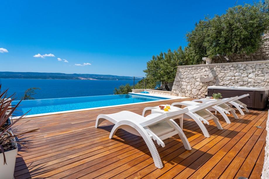 Pool level, middle-level offers heated, infinity 4m x 8m swimming pool with hydro massage, a Whirlpool next to the pool, 8 sundeck chairs, 2 parasols