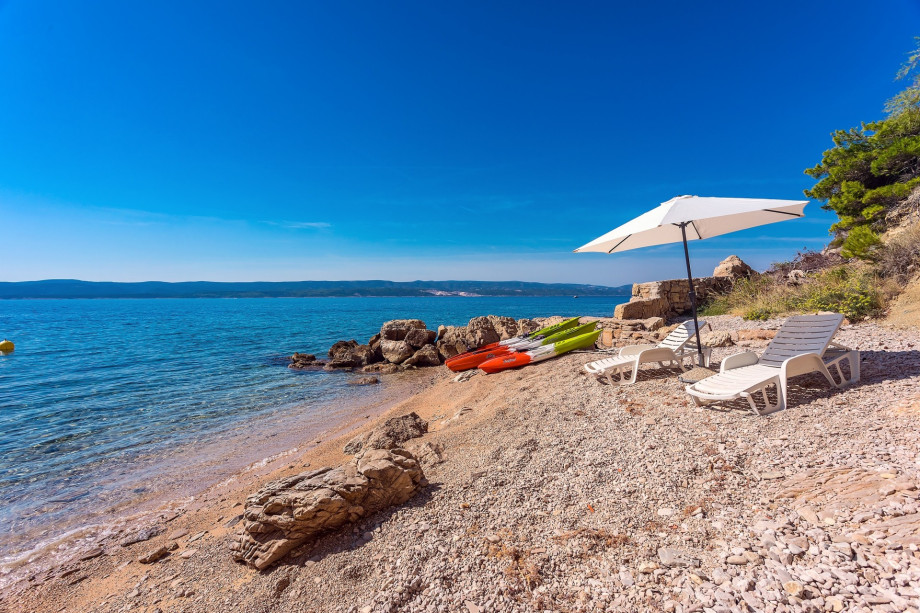 Your private beach with three canoes, beach chairs, a parasol and shower
