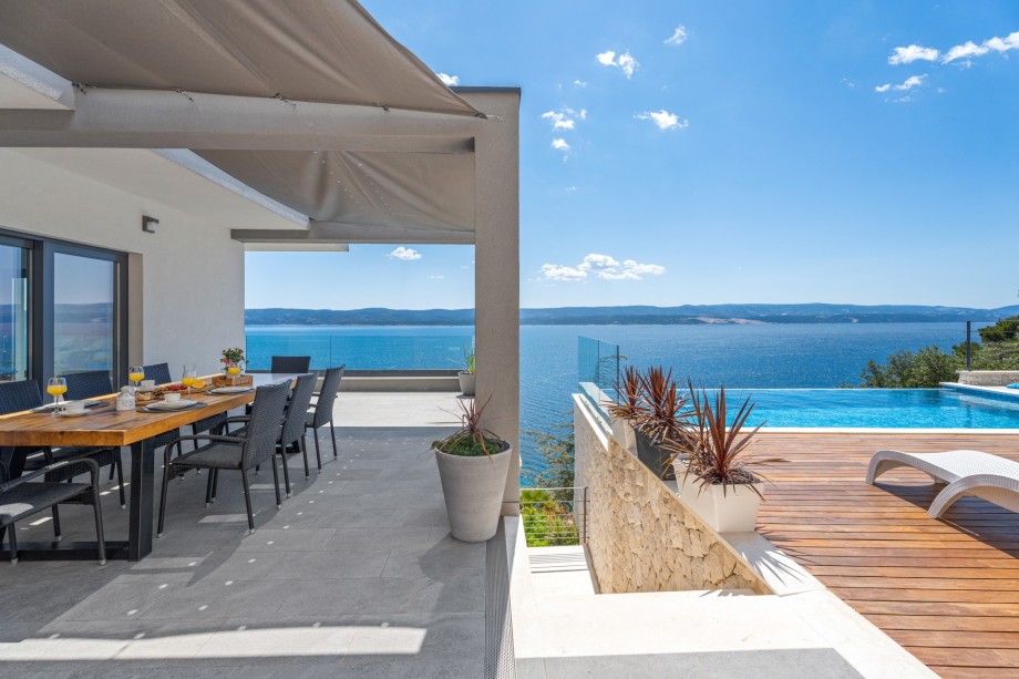 Outdoor dining area with BBQ on the pool (middle) level