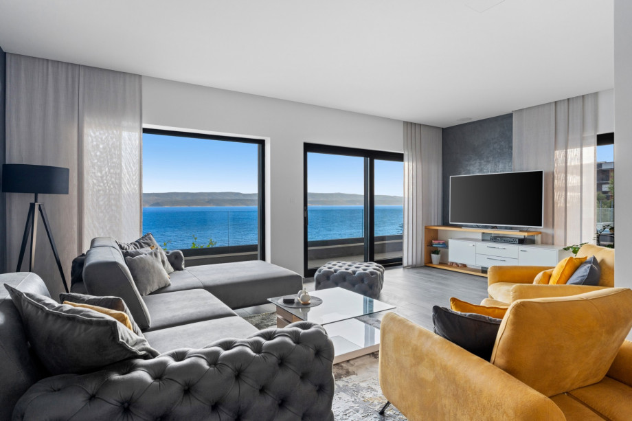 A spacious and stylish living room (middle level) offers a flat-screen TV, comfy sofas