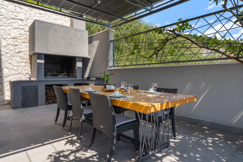 Outdoor dining area with BBQ on the east side of the villa (lowest level)