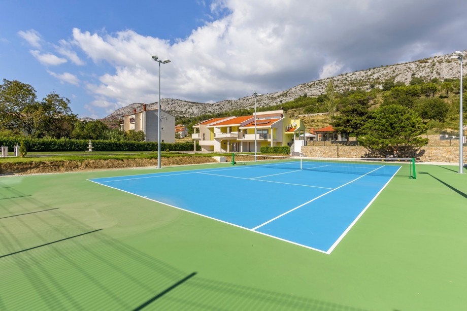 Artificial grass tennis court equipped with racquets