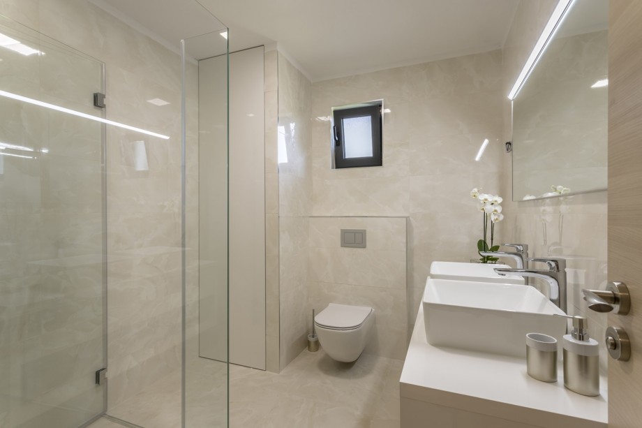 A family bathroom No1 with a shower, two sinks, a washing machine, and a dryer.