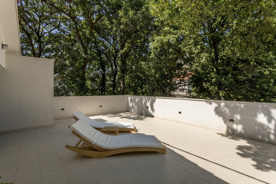 A terrace with two deck chairs and natural shade from oak trees (Bedroom No1 and4)
