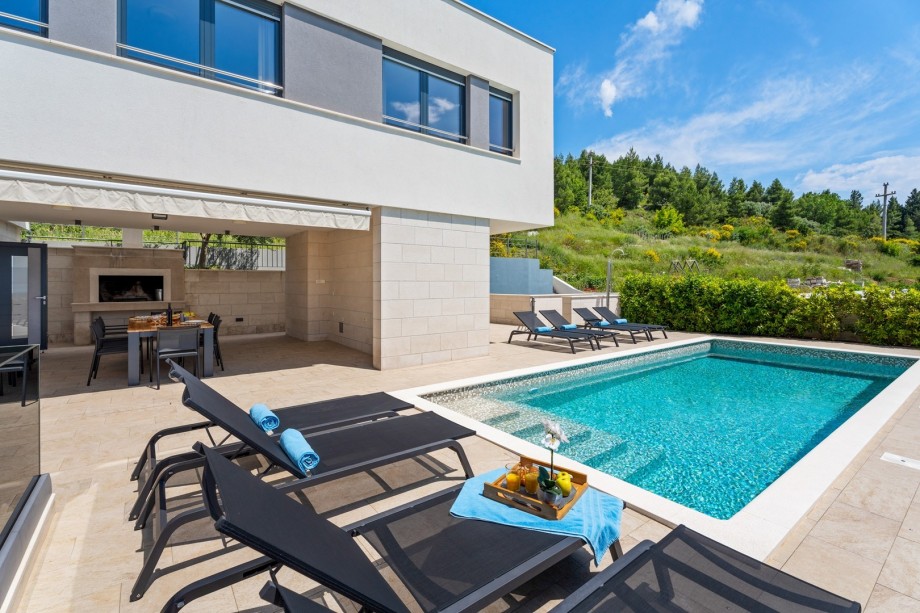 Sun deck area with heated pool, 6 deck chairs and amazing sea views