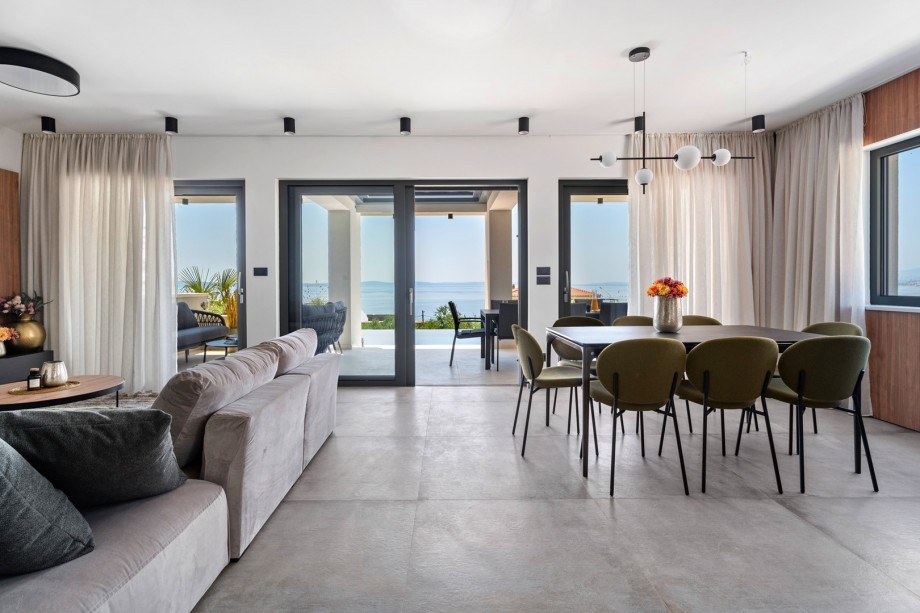 A stylish living area with flat-screen TV, A/C, an Ethanol fireplace, direct exit to the outdoor dining area and pool