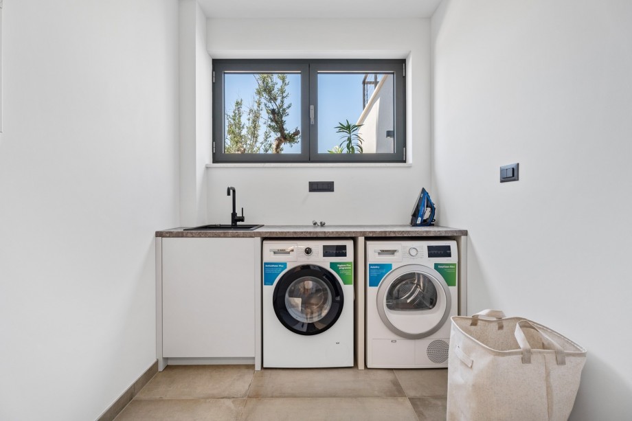 There is also a laundry with a washing machine, a dryer, and ironing amenities.