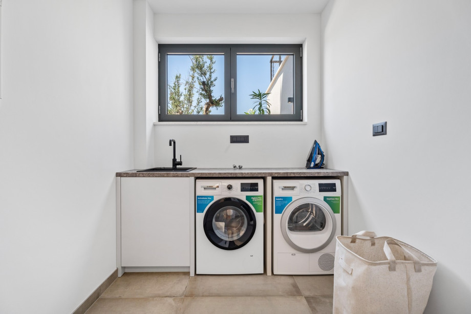 There is also a laundry with a washing machine, a dryer, and ironing amenities.