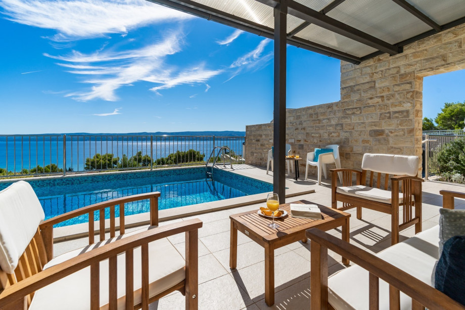 The outdoor sitting area next to the pool, amazing sea view