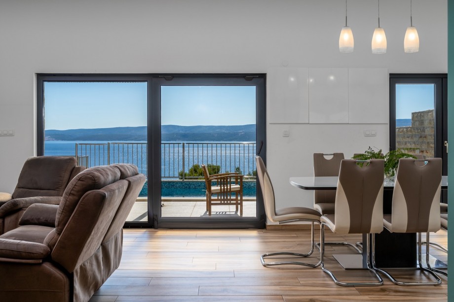 The living area has glass walls toward the pool and outdoor area