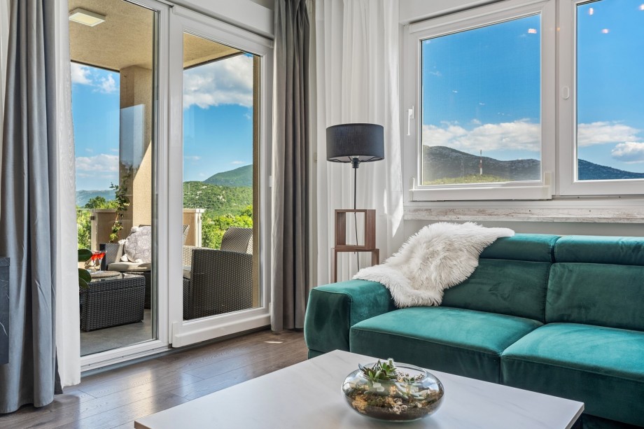 Villa BEYBE interior offers an Airconditioned Living and dining area with TV, and an exit to the outdoor lounge corner with a view of a pool area