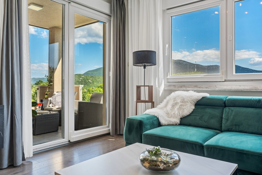 Villa BEYBE interior offers an Airconditioned Living and dining area with TV, and an exit to the outdoor lounge corner with a view of a pool area