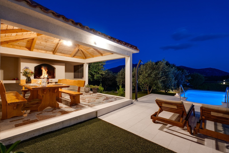 Comfortable and covered outdoor dining area with a traditional barbecue