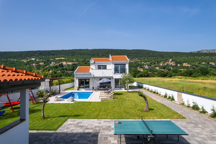 The outdoor area offers a covered outdoor dining area with the traditional barbecue