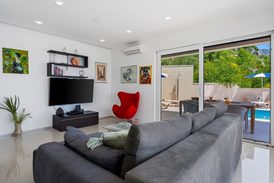 Living room offers a comfortable sofa with a flat-screen TV, PlayStation 4, and more.