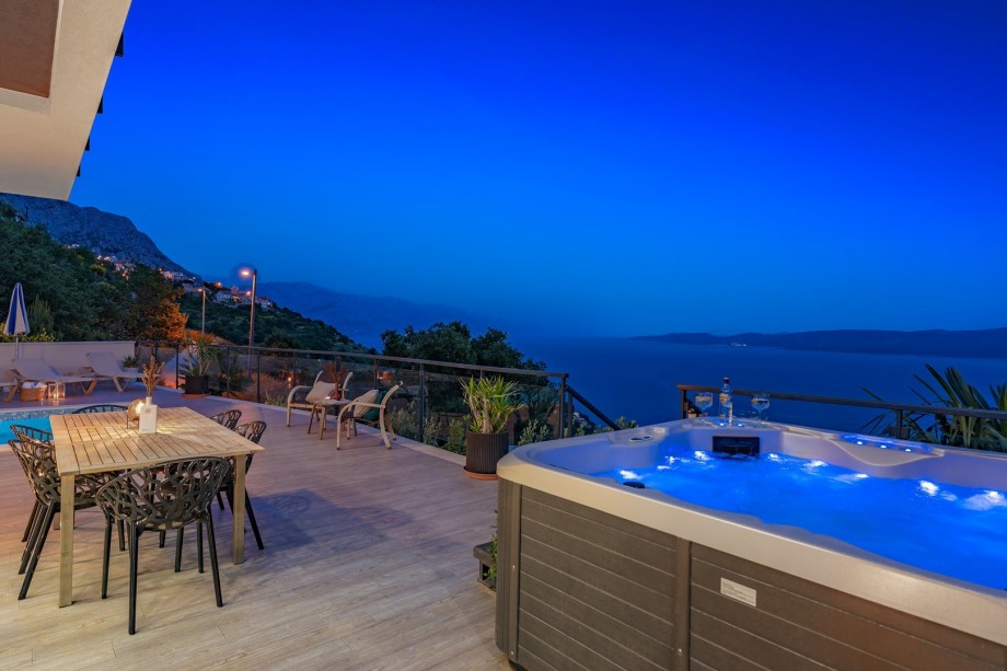 A poolside oasis with azure water, comfortable furniture, and a beautiful view.